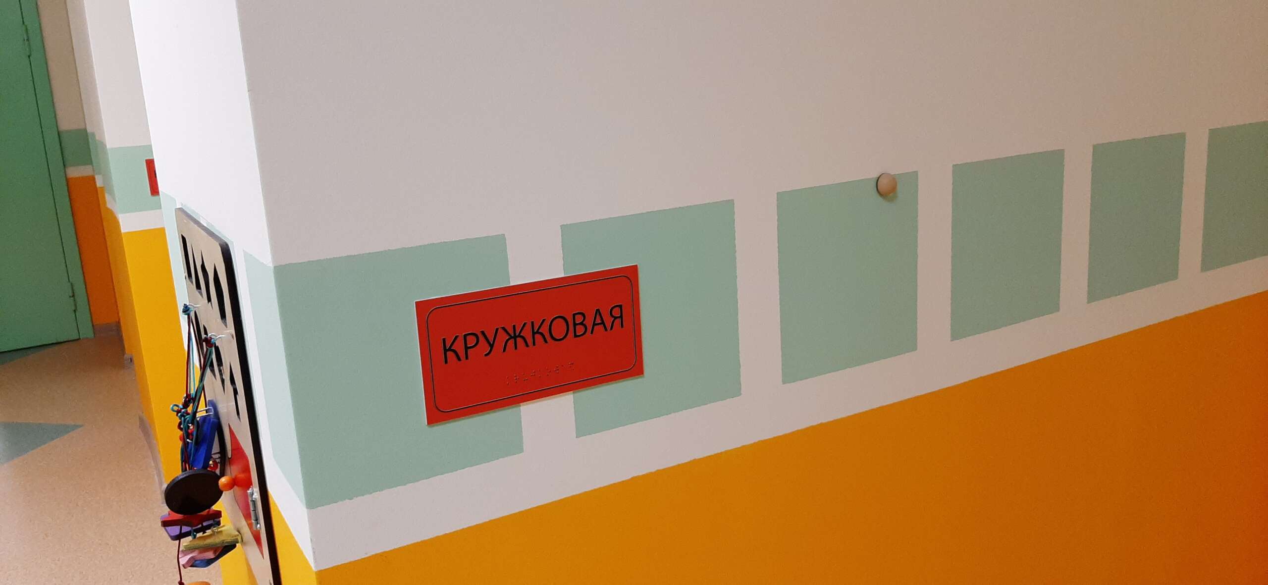 Тактильная табличка названия кабинета на контрастном фоне, дублирующая азбука Брайля