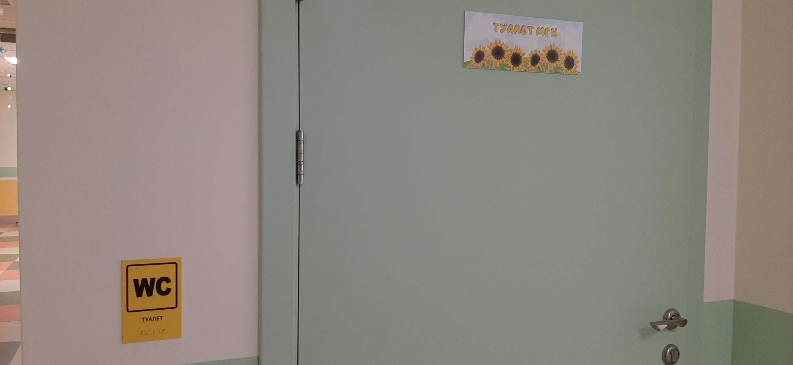 Туалет МГН с табличкой, выполненной на контрастном фоне, дублирующая азбука Брайля
